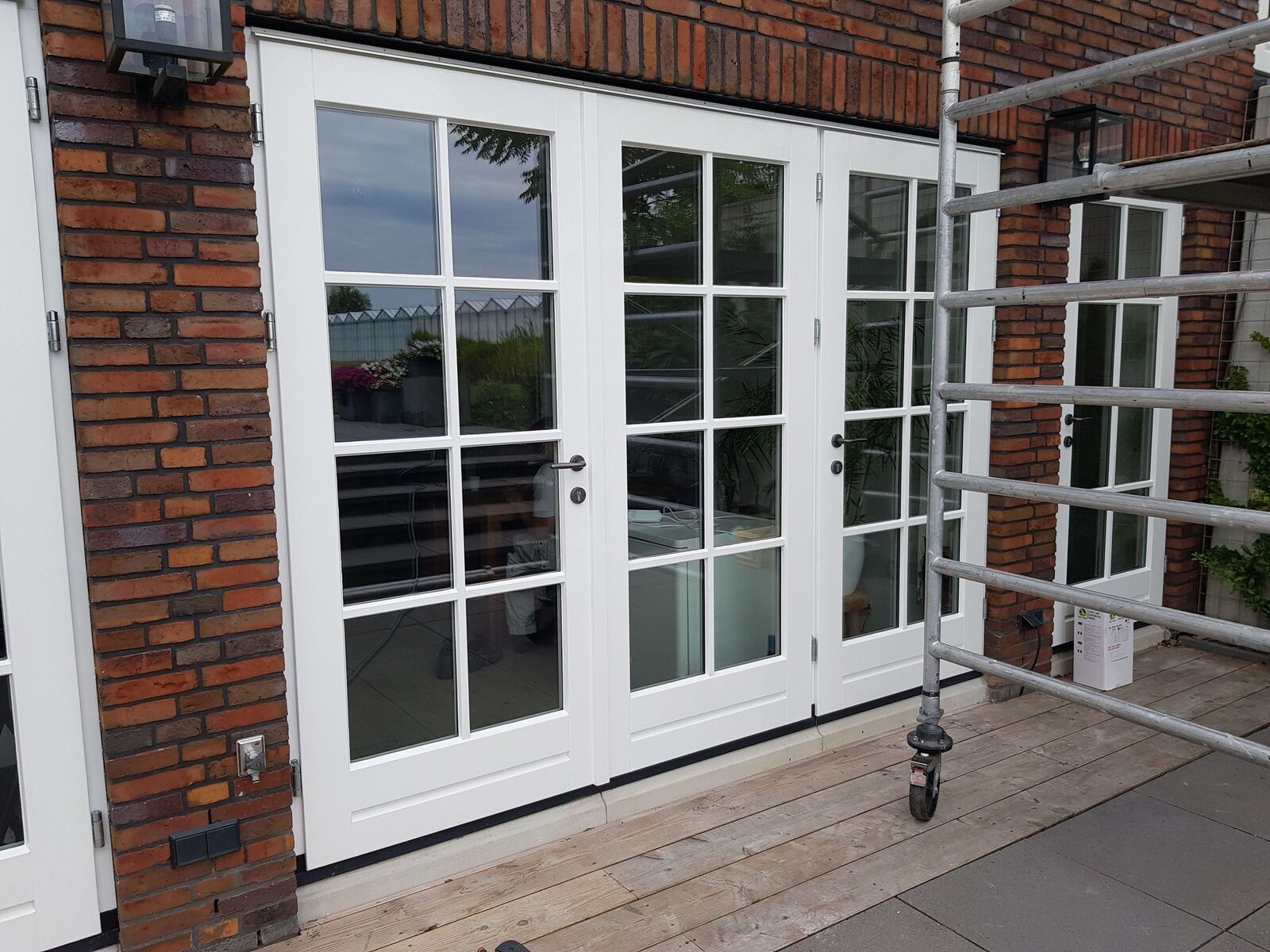 Vers geschilderde witte tuindeuren en kozijnen aan een woning